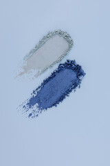 Top view of two beautiful parallel strokes of blue shades of eyeshadow. texture of decorative cosmetics. vertical blue background. A copy space.