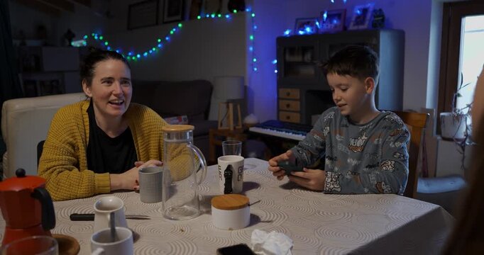 A mother and son share a laugh and a sense of complicity as they play the 'Impostor' mobile game together.