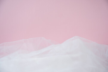 Soft pink background with ethereal tulle fabric texture. Abstract romantic backdrop with copy space for Valentine's Day, wedding, or beauty products