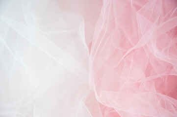Abstract background of soft white and pink tulle fabric. Delicate mesh texture for wedding, bridal, or romantic feminine designs