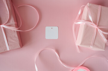 Top view of pink gift boxes with satin ribbons on a pink background. Minimalist feminine flat lay with copy space for Valentine's Day, Birthday or Mother's Day
