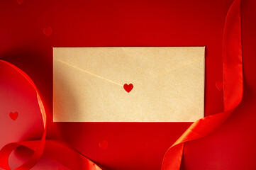 Craft paper envelope with red heart seal on red background with silk ribbon. Valentine's Day love letter concept