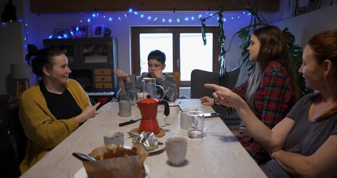 Family members use humour and gestures when discussing who the impostor in the game is.