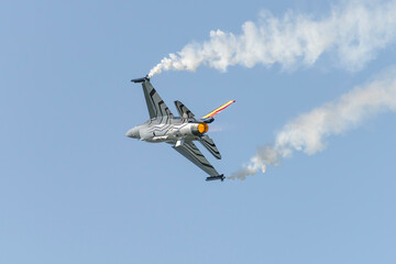 Wojskowy odrzutowy samolot myśliwski wystrzeliwujący flary podczas pokazów lotniczych © piotr