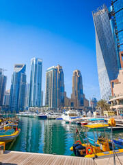 Fototapeta premium 01 08 2026 - Dubai, United Arab Emirates. Dubai Marina pier with many luxury yachts, capturing modern waterfront and city skyline with skyscrapers. Floating boats on canal