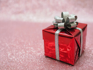 Festive Red Gift Box with Silver Bow on Sparkling Pink