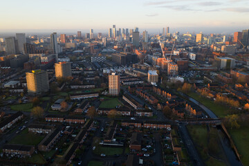 Aerial image looking southwest from Miles Platting across the Rochdale Canal toward the high-density skyscrapers of Manchester city center at sunrise.