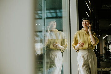 Happy woman talking on the phone in a modern office setting