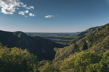 Vista panor&aacute;mica de un valle monta&ntilde;oso bajo un cielo azul despejado en la hora dorada.