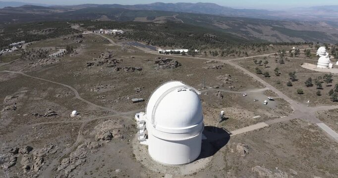 Top down drone aerial of Calar Alto Observatory dome, Tabernas Spain, white telescope building on barren mountain terrain with access roads