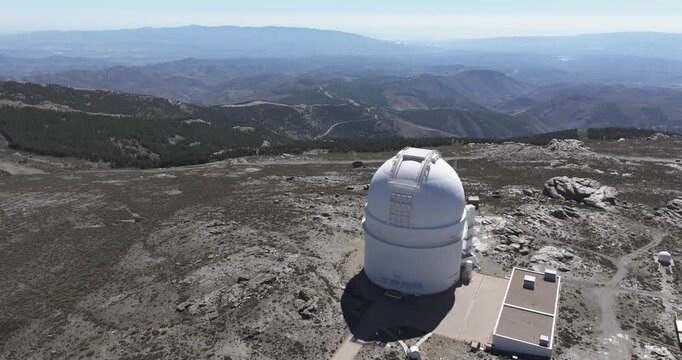 Drone aerial over Calar Alto Observatory dome, Tabernas Spain, isolated astronomy station on rocky summit with sweeping mountain panorama