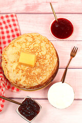Delicious Russian pancakes with jam, soft cottage cheese, preserves, sour cream, and honey on a marble table. Healthy breakfast made from natural ingredients, Maslenitsa concept, natural products