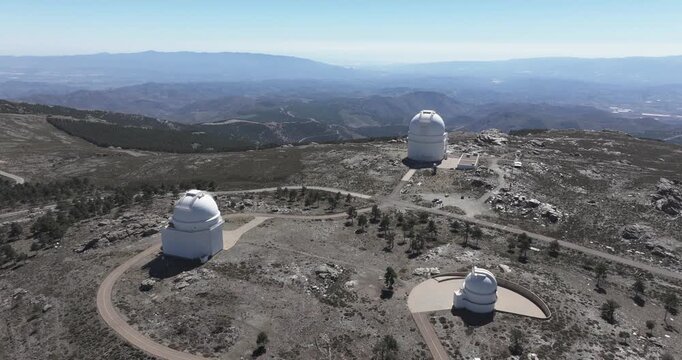 Drone aerial showing Calar Alto Observatory dome and surrounding buildings, Tabernas Spain, astronomy research station on rocky mountain plateau
