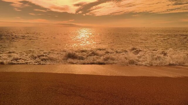 Slow Motion Ocean Waves on a Wide Beach during Golden Sunset