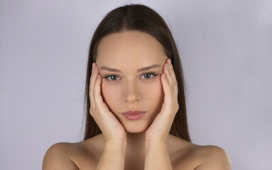 portrait of a beautiful white young woman with brown hair and blue eyes on a neutral background
