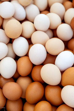 Fresh brown and white eggs stacked closely together