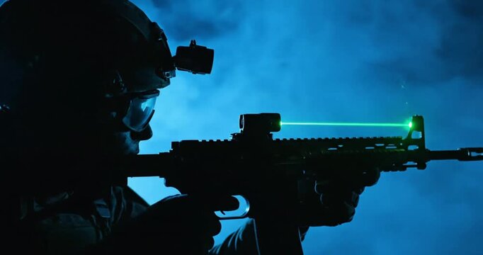 Special Forces Soldier Aiming Rifle with Green Laser Sight at Night

