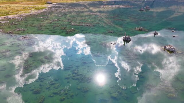 CALIFORNIA - 11.3.2025 - Beautiful aerial footage skimming across California's Mono Lake shows clouds reflected in its surface.