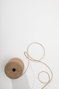 Spool of natural twine on white surface