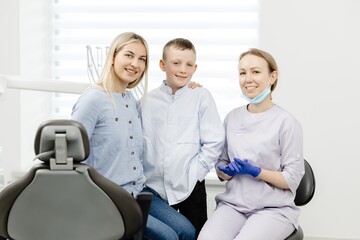 Mother and son smiling with dentist in dental clinic