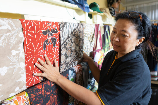 Examining colorful batik fabrics on display