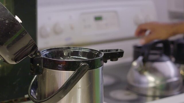 Close-up shot of the moment when a thermos is filled with hot water that has just been cooked.