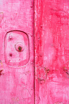 Weathered pink door texture with rusty details