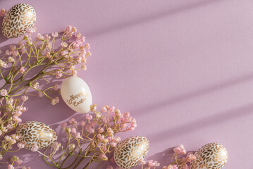 Pastel Easter Eggs with Gold Details and Flowers on Lavender Background