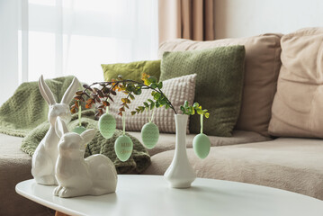 Cozy Easter Living Room Decor with Bunny Figurines and Hanging Eggs on White Table