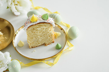 Cutted Easter Cake Decorated Yellow Ribbon with Flowers and Pastel Eggs on White Background
