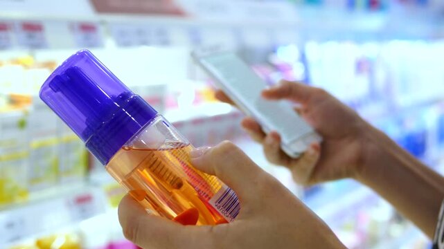 Close up of female hands holding two beauty products in a cosmetics aisle, carefully comparing their ingredients and choosing the best option for her skin care routine in a modern store