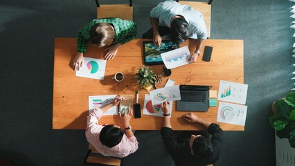 Top down view of smart business people hand working together to analyze chart. Skilled marketing team discussing about financial plan at table with stock market exchange report placed. Convocation.