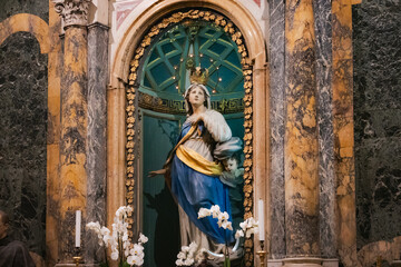 Obraz premium Historic Baroque statue of the Immaculate Conception inside the Basilica di San Francesco in Ravenna, Italy. The marble monument features a blue and gold niche background.