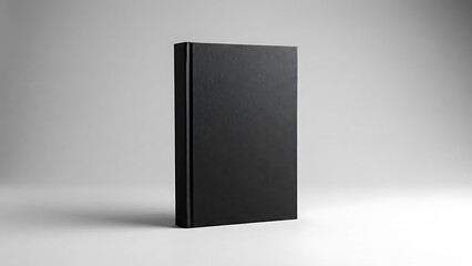 a black book with a plain cover standing upright on a white surface