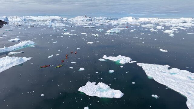 GREENLAND - 11.4.2025 - Excellent aerial footage of kayakers moving past ice floes on Greenland's Disko Bay.