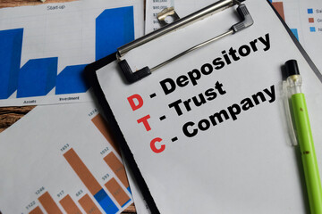 Concept of DTC - Depository Trust Company write on clipboard isolated on Wooden Table. © syahrir
