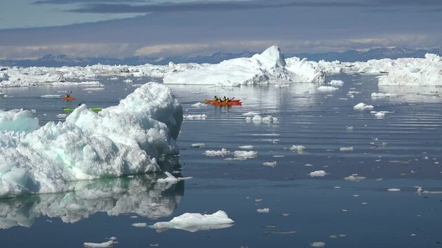 GREENLAND - 11.4.2025 - Great aerial view of people kayaking through an ice field on Greenland's Disko Bay.