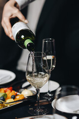 Pouring White Wine at Elegant Dinner