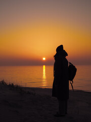 Fototapeta premium Female Traveler Standing On Sand Dune At Baltic Sea Sunset In Nida