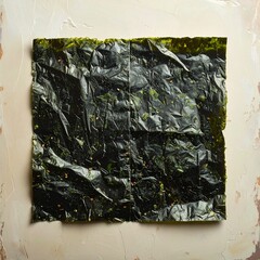 A Crumpled Sheet of Seaweed on a Textured Surface Background