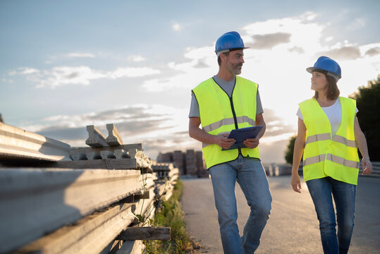 Outdoor Images of a Thirty Five Year Old Man and Woman Construction Workers Planning Work Talking and Taking a Break