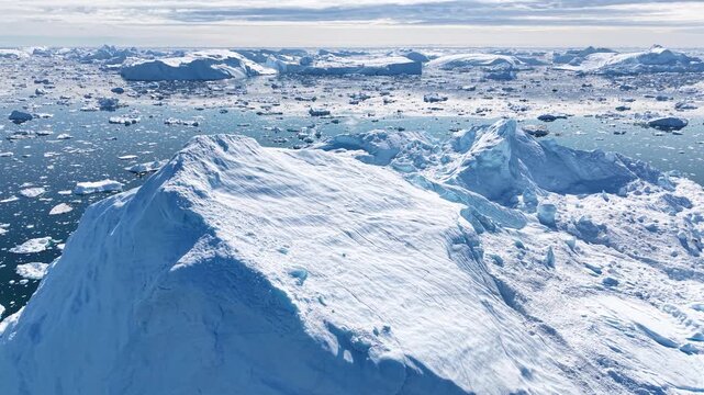 GREENLAND - 11.4.2025 - Breathtaking aerial footage starting to circle clockwise around a large iceberg on Greenland's Disko Bay.