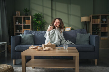 Obraz premium Woman enjoying comfortable morning tea on sofa at home