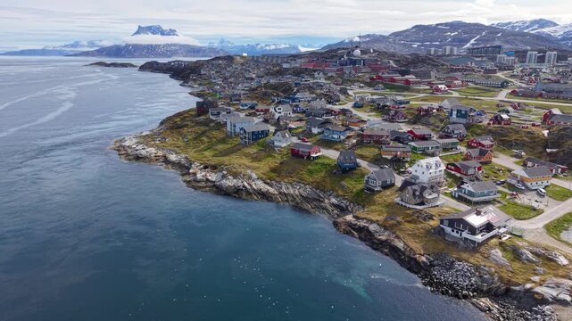 GREENLAND - 11.4.2025 - Fantastic aerial view of colorful buildings on the coast of Nuuk, Greenland, with a misty mountain in the background.