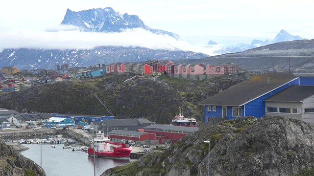 GREENLAND - 11.4.2025 - Very good aerial view of a harbor in Nuuk, Greenland with misty mountains in the background.