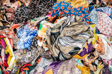 Close-up of mixed colorful fabric scraps in fashion studio, symbolizing textile design, reuse, creativity, and sustainable clothing production.