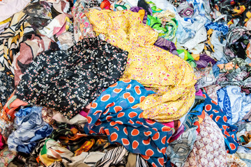 Close-up of mixed colorful fabric scraps in fashion studio, symbolizing textile design, reuse, creativity, and sustainable clothing production.