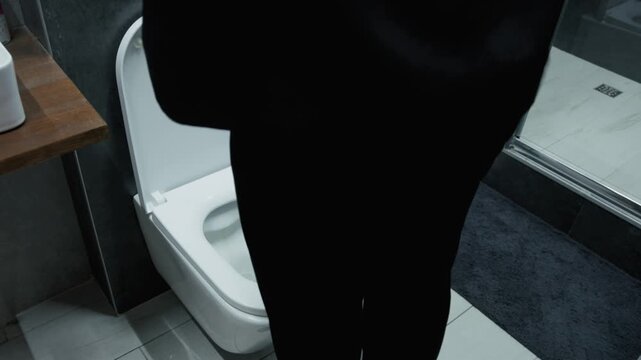 A stressed businessman sits on a toilet with a tense expression, facing sudden digestive problems. Everyday reality, discomfort, vulnerability. Concept stress, health, work pressure