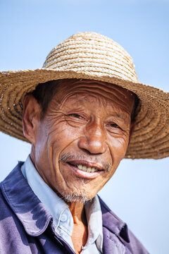 Portrait of Elderly Chinese Man in Straw Hat Smiling, China