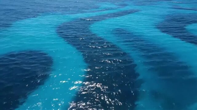 Dramatic aerial view of a ship s wake creating mesmerizing patterns on turquoise ocean water evoking feelings of travel adventure and vastness